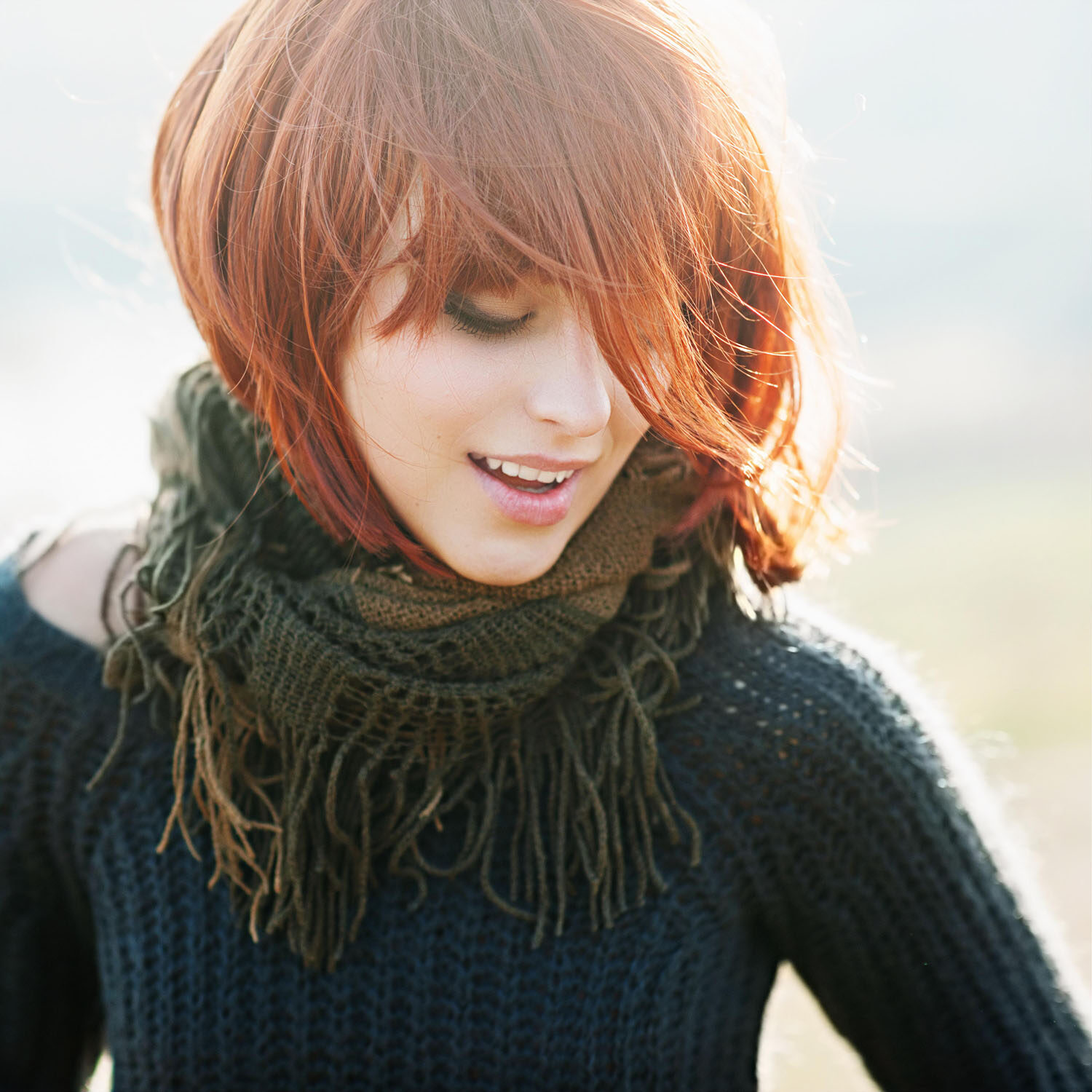 A woman with red hair and wearing a scarf.